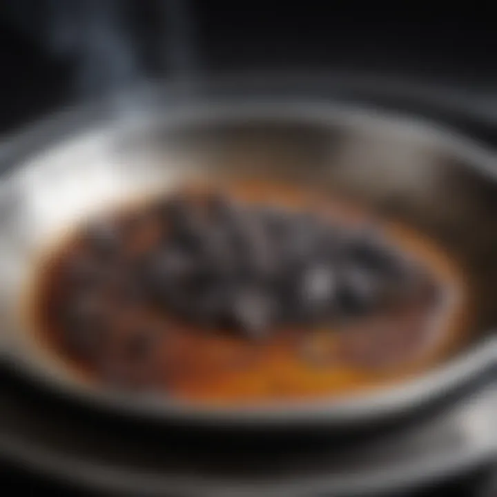 Close-up of burnt residue on a stainless steel pan