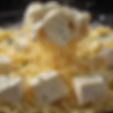 Close-up of creamy feta cheese melting into cooked pasta.