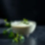 A vibrant bowl of yogurt dressing garnished with herbs.